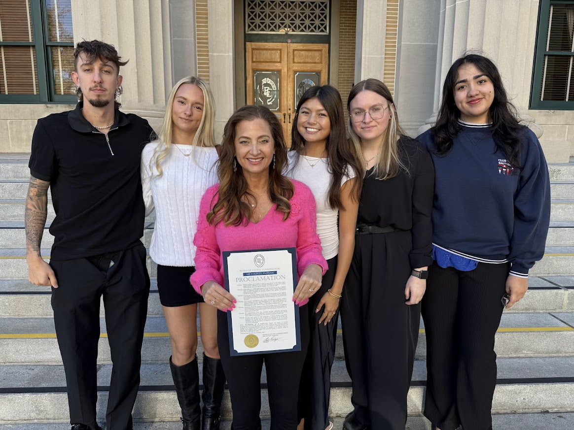 Angela Melvin with Valerie’s House teen ambassadors holding proclamation after being honored for 10 years of supporting grieving children and families