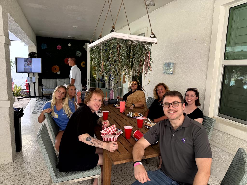Group of volunteers gathered around a table at Valerie’s House Fort Myers Family is Forever Home