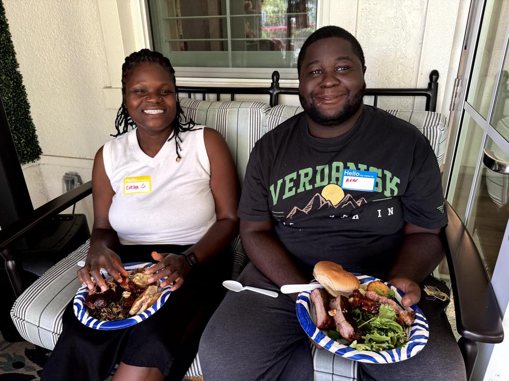 Two volunteers smiling with plates of food during Valerie’s House appreciation event