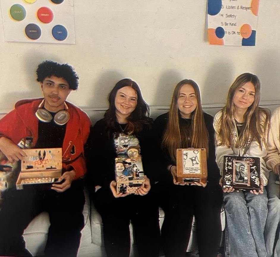 Teens at Valerie’s House holding decorated memory boxes honoring loved ones during a grief support group at the Fort Myers Family is Forever Home.